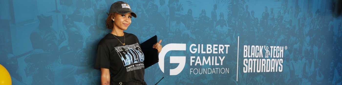 Tia James at a Black Tech Saturdays event backdrop with the Gilbert Family Foundation